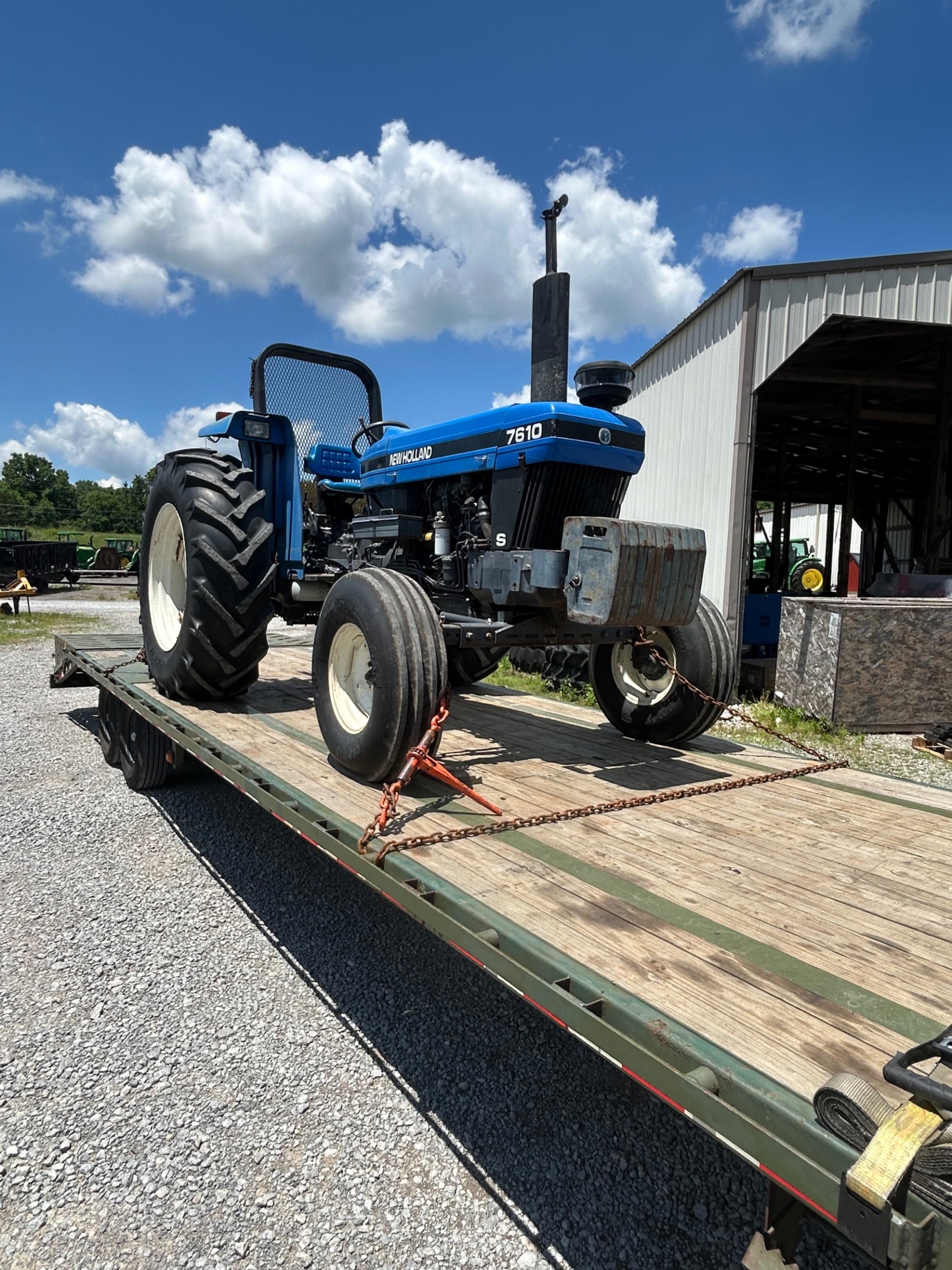 Blue tractor loaded on a BigWay flatbed trailer