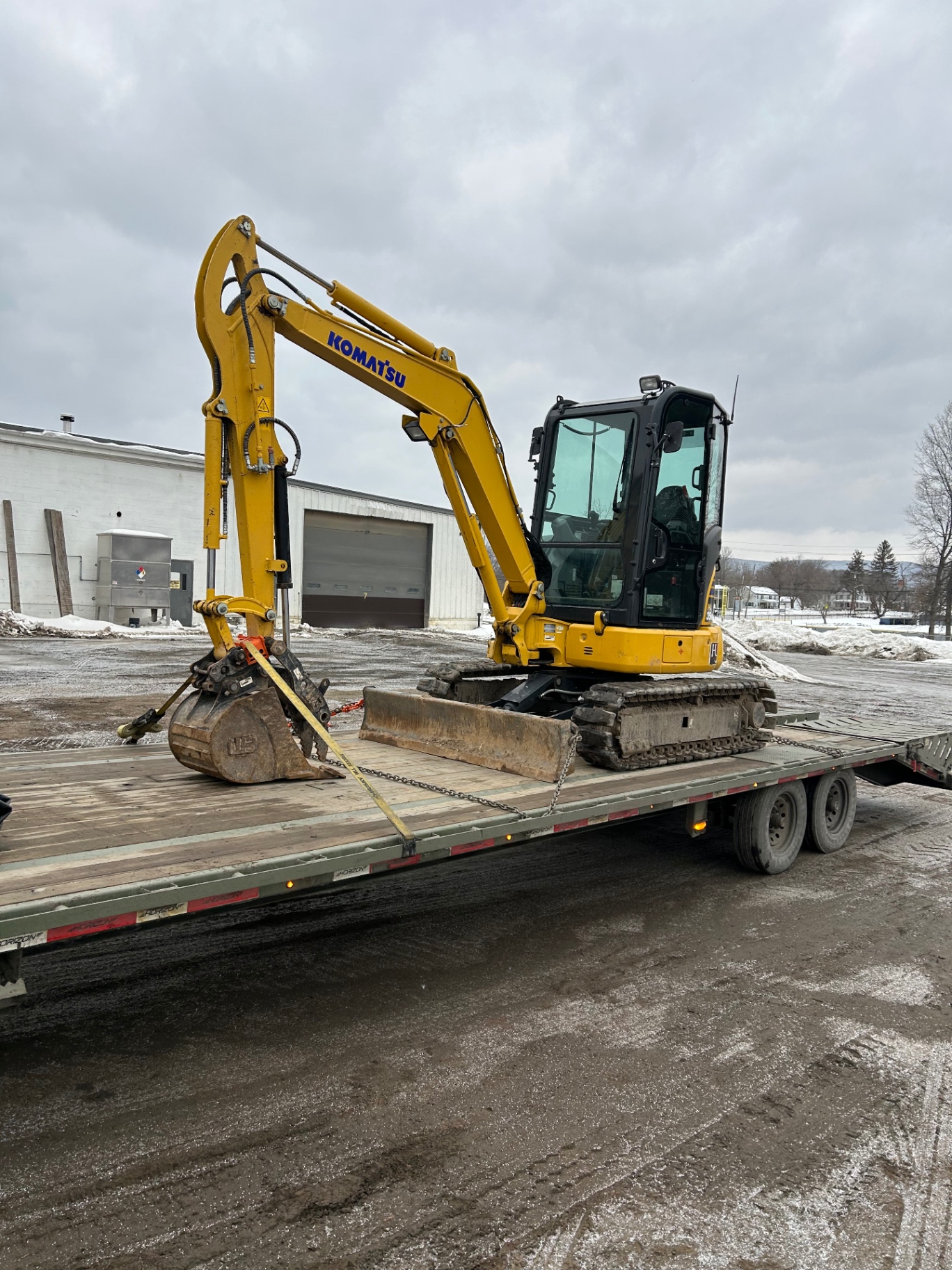 Komatsu excavator ready for delivery on a flatbed trailer