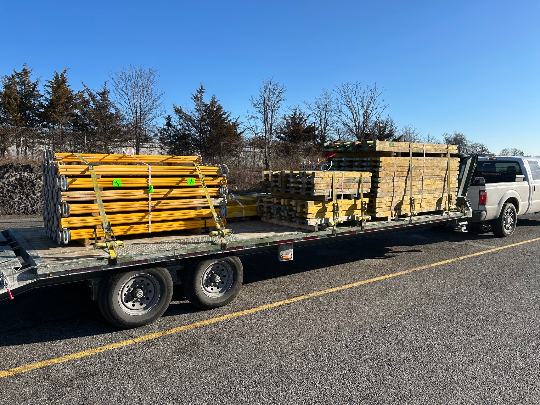 Scaffolding and jobsite materials strapped on a flatbed trailer