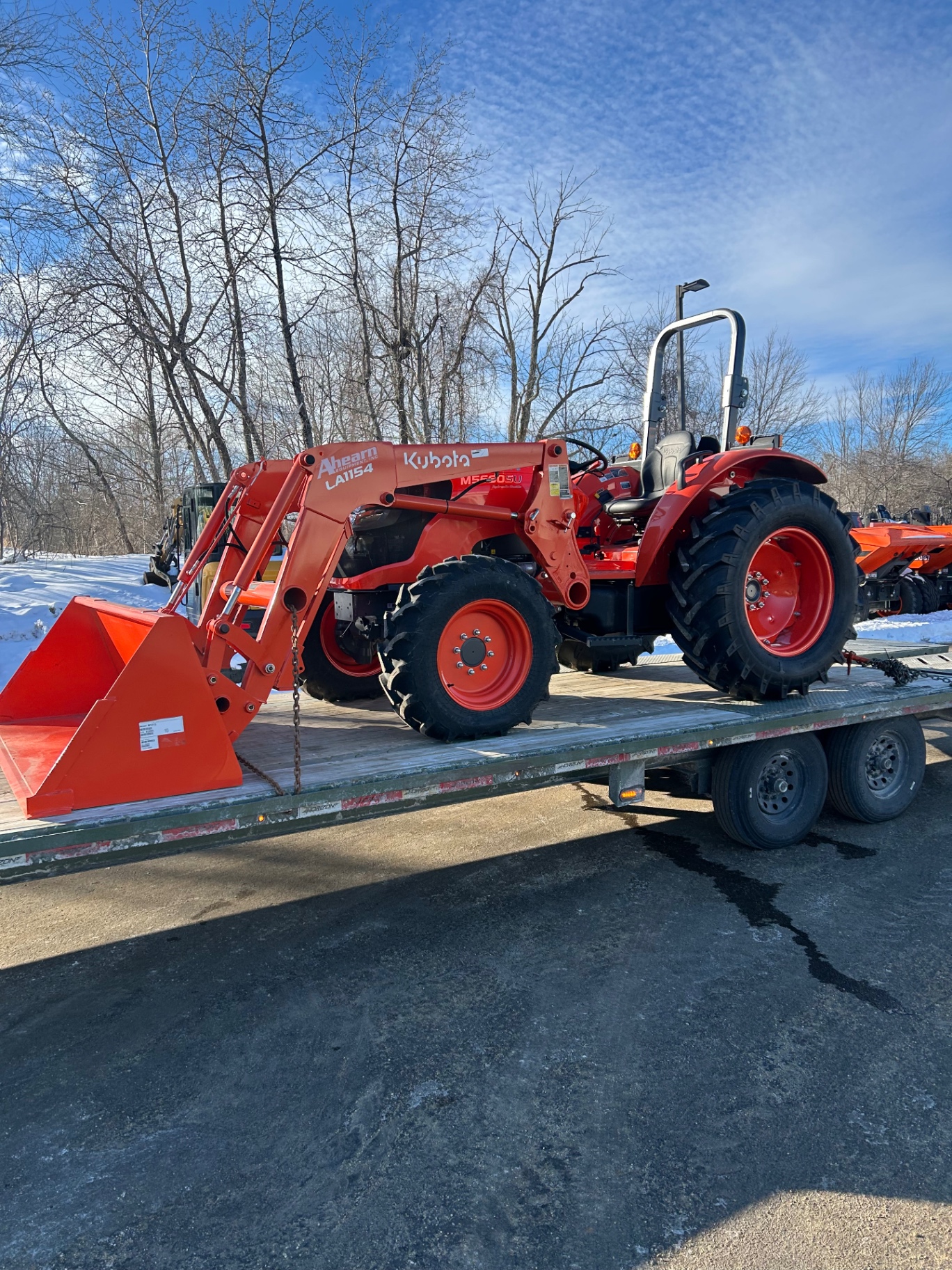 Kubota tractor secured for transport on a gooseneck trailer